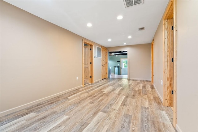spare room with light wood-type flooring, baseboards, and recessed lighting
