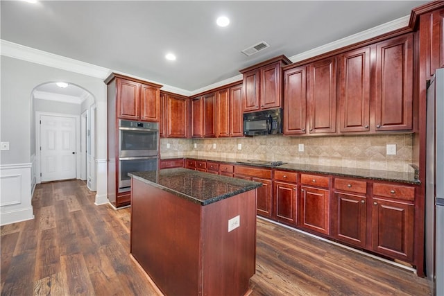 151 Landing Way, Smiths Station, AL 36877 - kitchen featuring black appliances, arched walkways, a kitchen island, dark brown cabinets, and ornamental molding