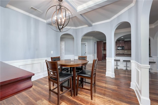 151 Landing Way, Smiths Station, AL 36877 - dining space with crown molding, a chandelier, dark wood-style floors, arched walkways, and wainscoting