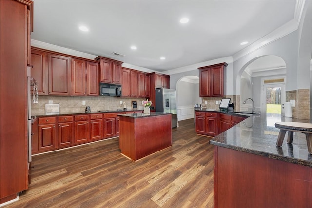 151 Landing Way, Smiths Station, AL 36877 - kitchen with black microwave, stainless steel fridge, dark brown cabinets, arched walkways, and ornamental molding