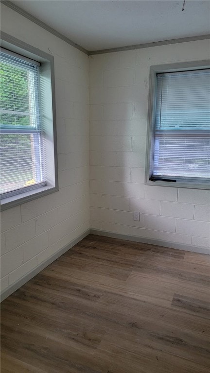 314 E Rosa Park, Tuskegee, AL 36083 - empty room with wood finished floors, ornamental molding, and concrete block wall