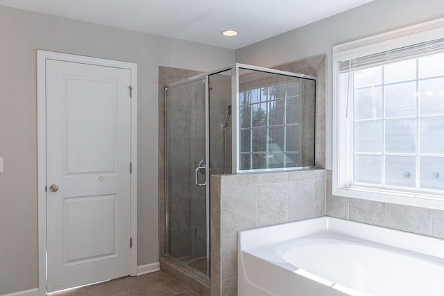 bathroom featuring tile patterned flooring and shower with separate bathtub