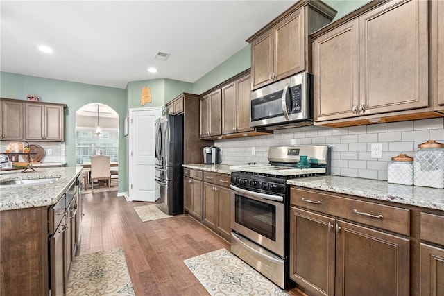 2655 Anderson Ct, Auburn, AL 36832 - kitchen with appliances with stainless steel finishes, dark wood-style flooring, decorative backsplash, light stone countertops, and recessed lighting