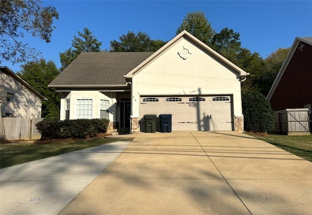 view of front of property with concrete driveway, fence, an attached garage, and stucco siding