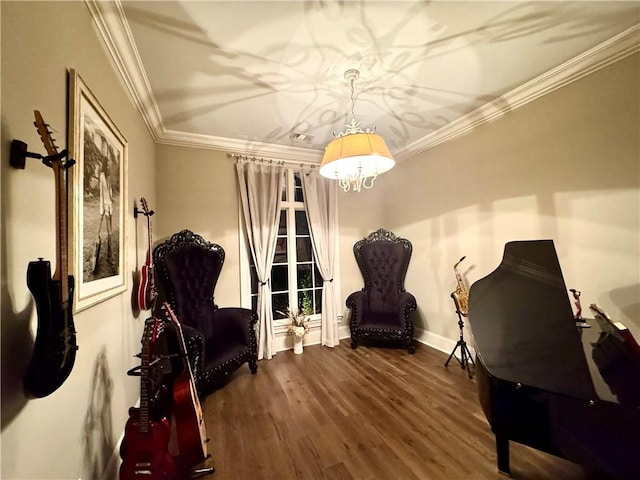 sitting room featuring dark wood-style flooring, ornamental molding, baseboards, and a chandelier