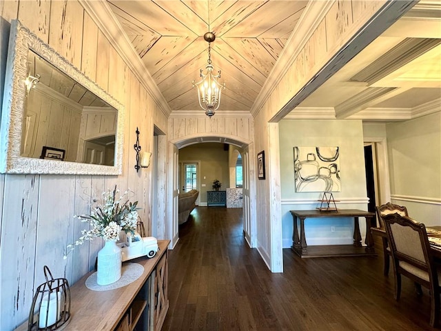 hallway featuring arched walkways, an inviting chandelier, ornamental molding, and dark wood finished floors
