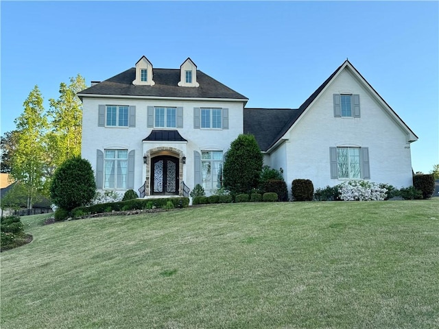 colonial home featuring a front yard and french doors