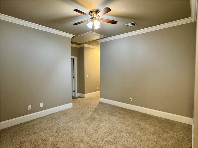 unfurnished room featuring attic access, crown molding, carpet floors, visible vents, and ceiling fan