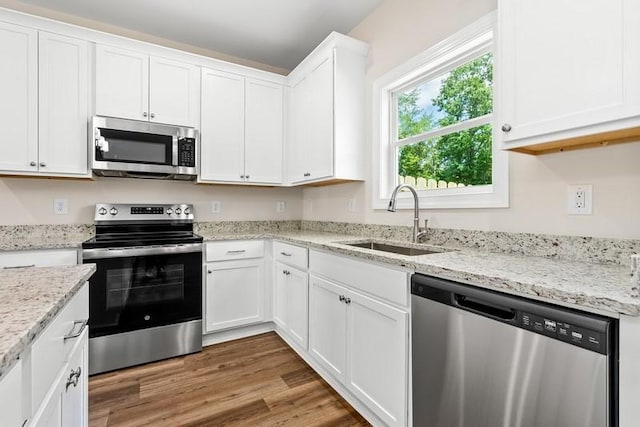 3260 Academy Dr Unit 408, Opelika, AL 36801 - kitchen with appliances with stainless steel finishes, white cabinetry, light wood-type flooring, and light stone countertops