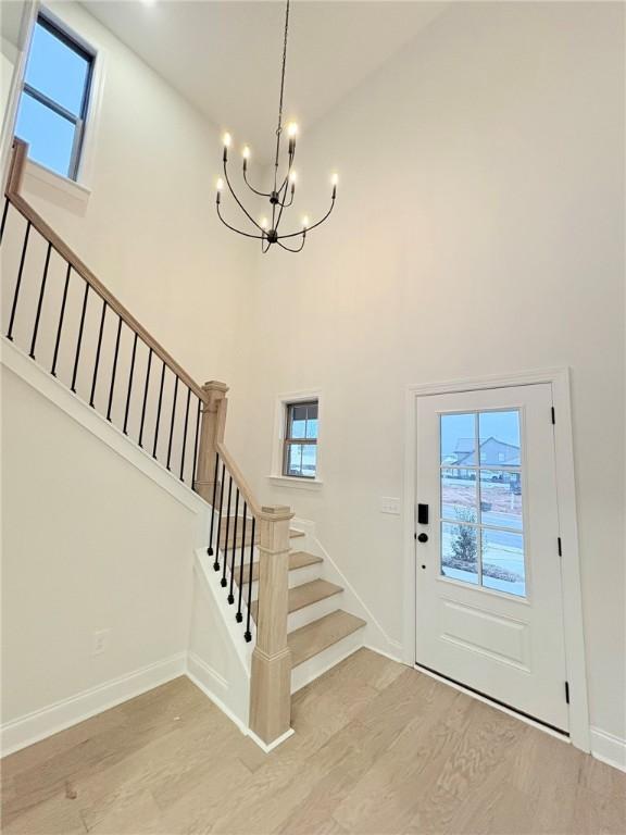 unfurnished living room featuring a brick fireplace, built in shelves, ceiling fan, light hardwood / wood-style flooring, and lofted ceiling