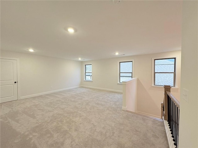 unfurnished bedroom featuring light carpet, ensuite bathroom, and a closet