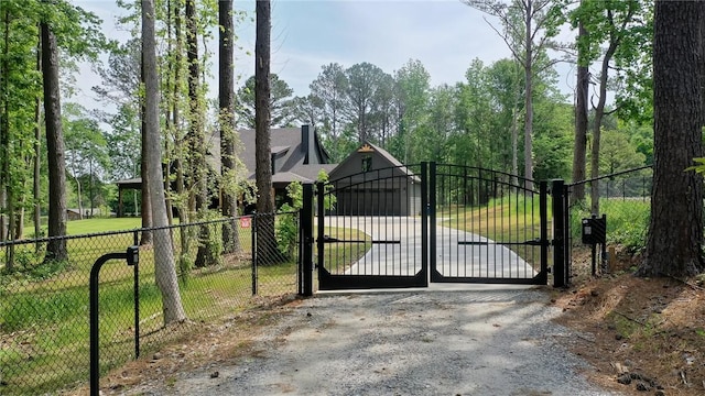 view of gate with fence and a lawn