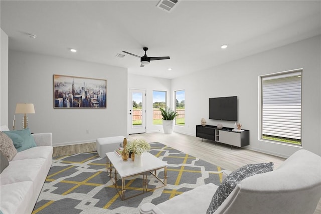 living area with baseboards, wood finished floors, visible vents, and recessed lighting