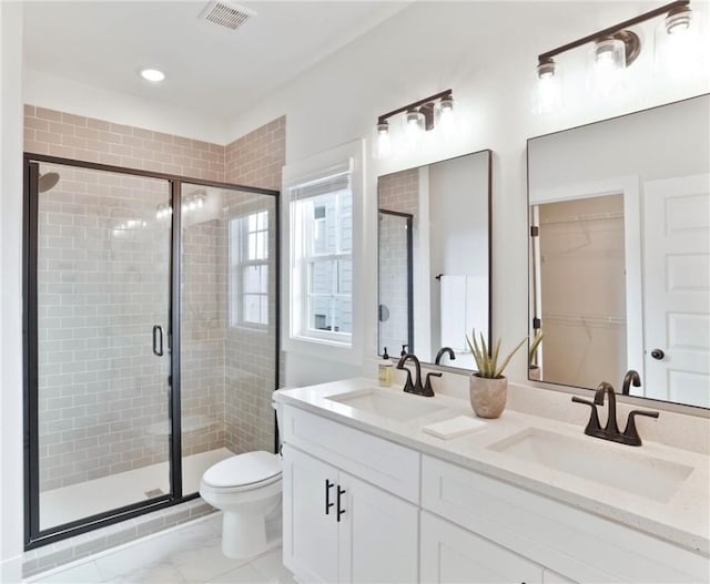 full bath featuring toilet, a sink, visible vents, and a stall shower