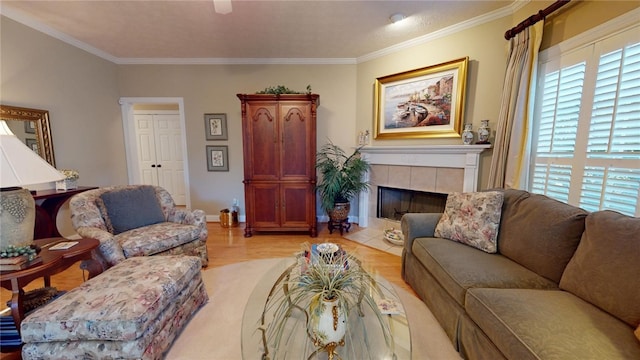 living room with a tiled fireplace, light hardwood / wood-style flooring, and ornamental molding