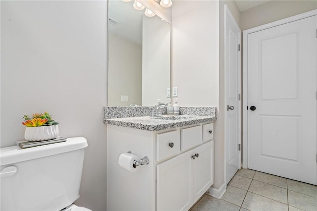bathroom featuring tile patterned flooring, toilet, and vanity