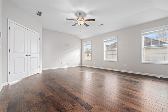 spare room with visible vents, lofted ceiling, ceiling fan, and dark wood-style flooring
