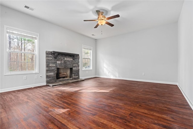 unfurnished living room featuring wood finished floors, a ceiling fan, visible vents, and baseboards