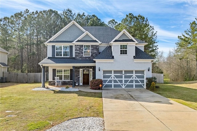 craftsman inspired home featuring a front lawn, fence, concrete driveway, stone siding, and an attached garage