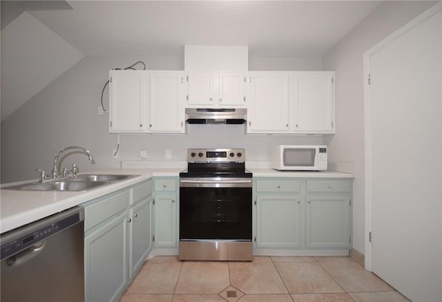 kitchen featuring stainless steel appliances, under cabinet range hood, a sink, and light countertops