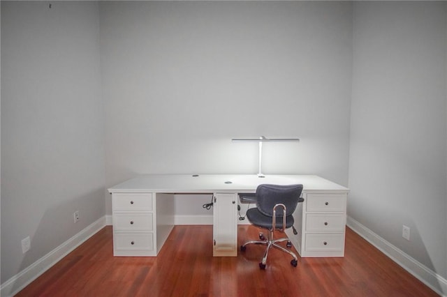 unfurnished office with dark wood-type flooring and baseboards