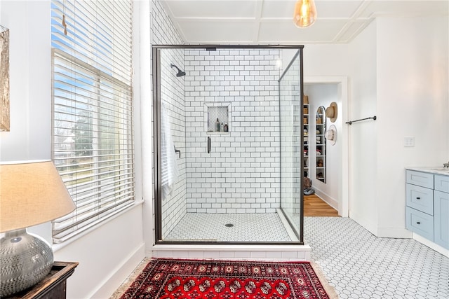 bathroom with a stall shower, vanity, and baseboards