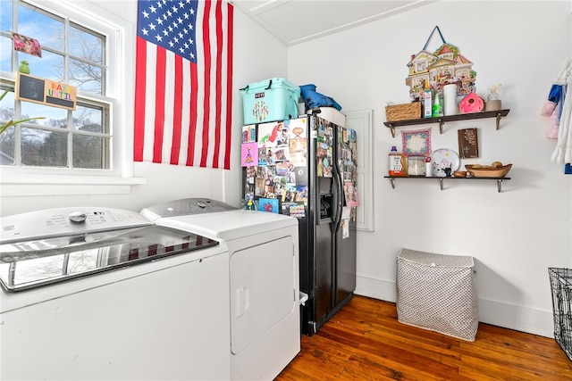 clothes washing area featuring laundry area, washer and clothes dryer, wood finished floors, and baseboards