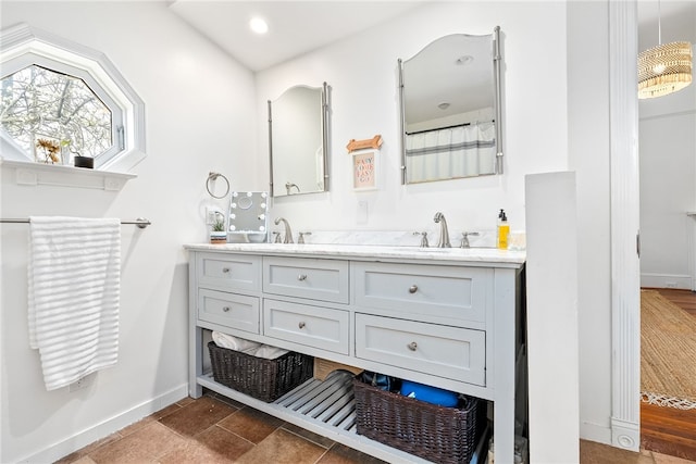 full bathroom with double vanity, recessed lighting, a sink, and baseboards