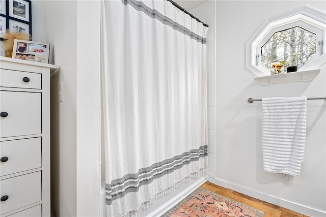 bathroom featuring baseboards and a shower with curtain