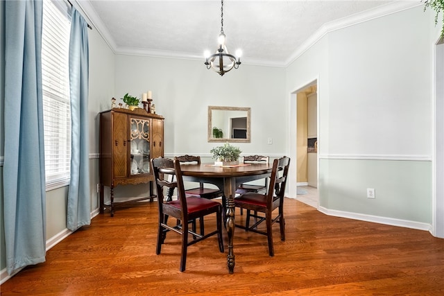 dining room featuring crown molding, baseboards, a notable chandelier, and wood finished floors