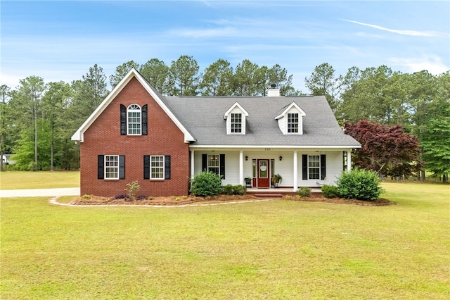 view of front facade with a porch, brick siding, a front lawn, and a chimney