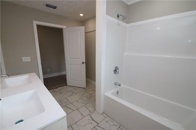 bathroom with vanity, shower / bath combination, and a textured ceiling