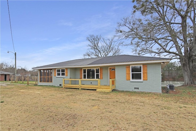 ranch-style home featuring cooling unit, a sunroom, and a front yard