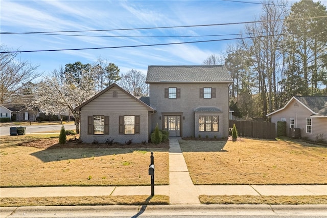 traditional-style home featuring fence and brick siding