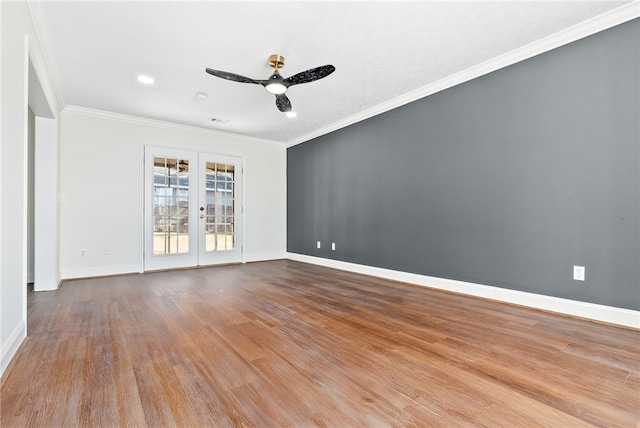 spare room with french doors, crown molding, a ceiling fan, wood finished floors, and baseboards