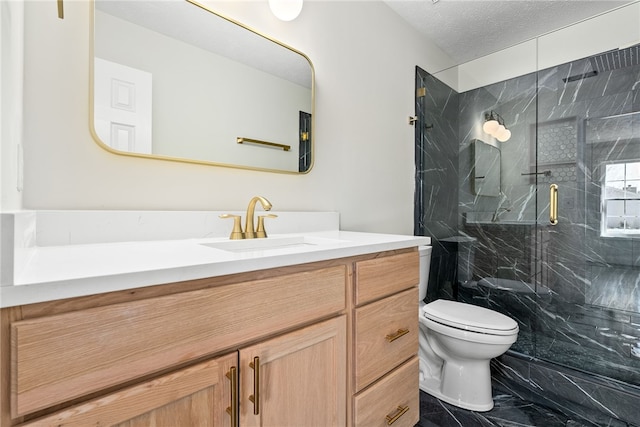 bathroom featuring marble finish floor, a marble finish shower, toilet, vanity, and a textured ceiling