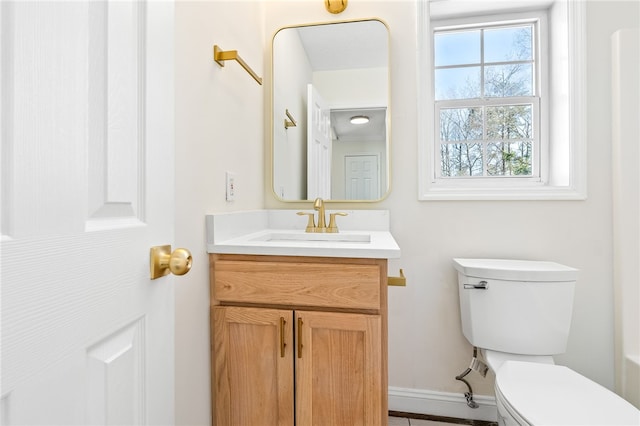 bathroom featuring baseboards, vanity, and toilet