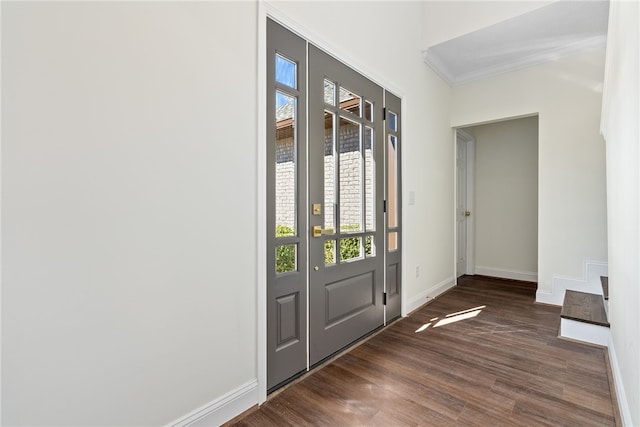 foyer with dark wood-style floors, baseboards, and ornamental molding