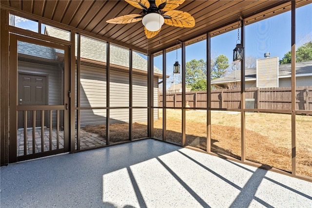 unfurnished sunroom featuring a ceiling fan