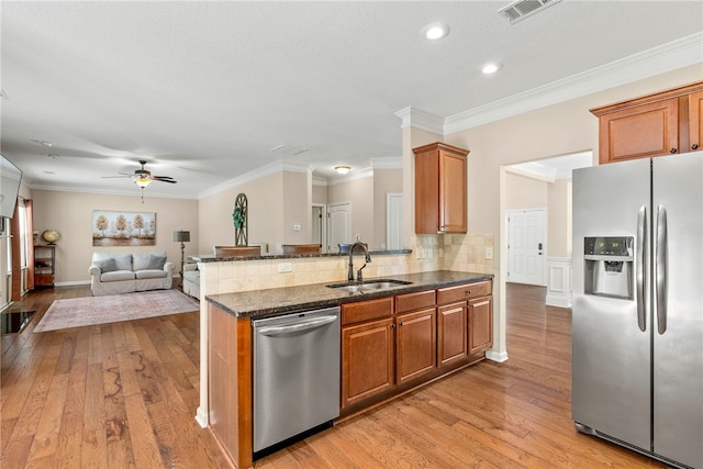 2113 Felicity Ln, Auburn, AL 36830 - kitchen featuring stainless steel appliances, a sink, light wood-style floors, ceiling fan, and dark stone countertops