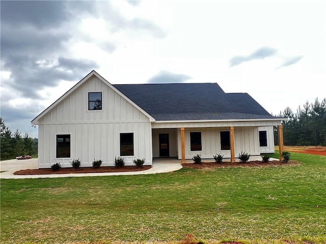 modern farmhouse with a shingled roof, board and batten siding, and a front lawn