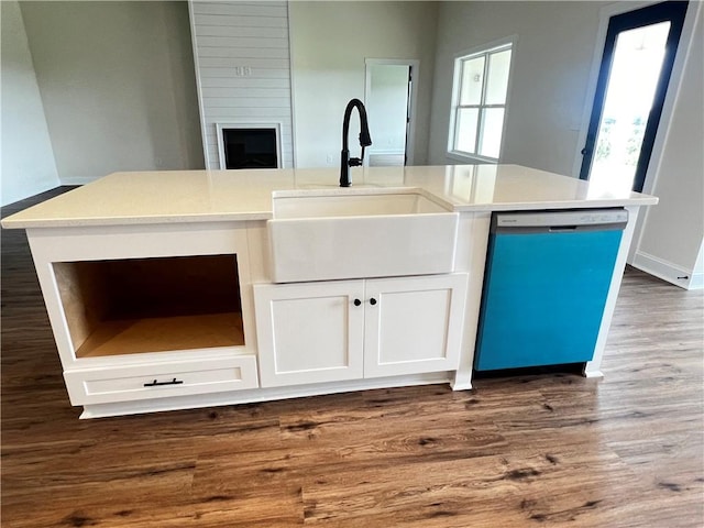 kitchen with dishwasher, a sink, light countertops, dark wood-style floors, and white cabinetry