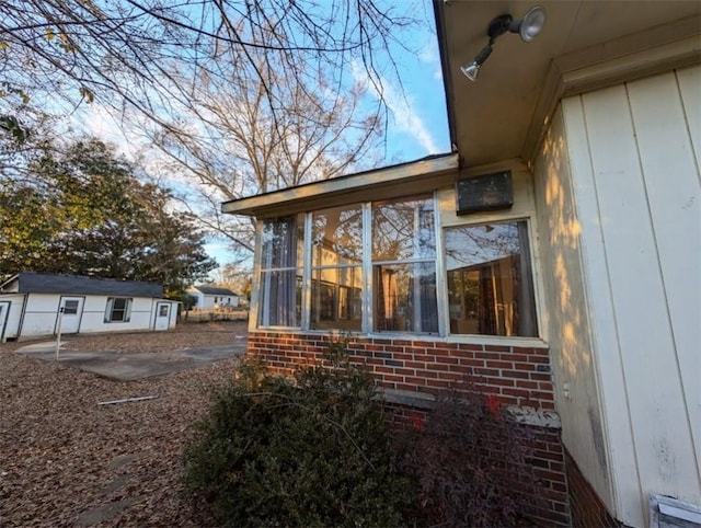 view of home's exterior with an outdoor structure and a sunroom