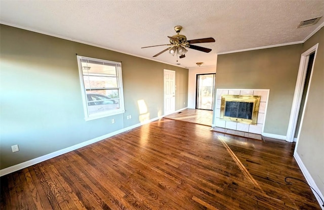 unfurnished living room featuring crown molding, a textured ceiling, a fireplace, and dark hardwood / wood-style flooring