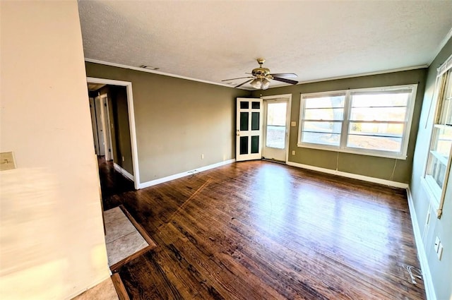 empty room featuring dark hardwood / wood-style flooring, ceiling fan, ornamental molding, and a textured ceiling