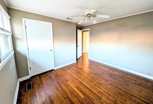 empty room featuring hardwood / wood-style floors, crown molding, a textured ceiling, and ceiling fan