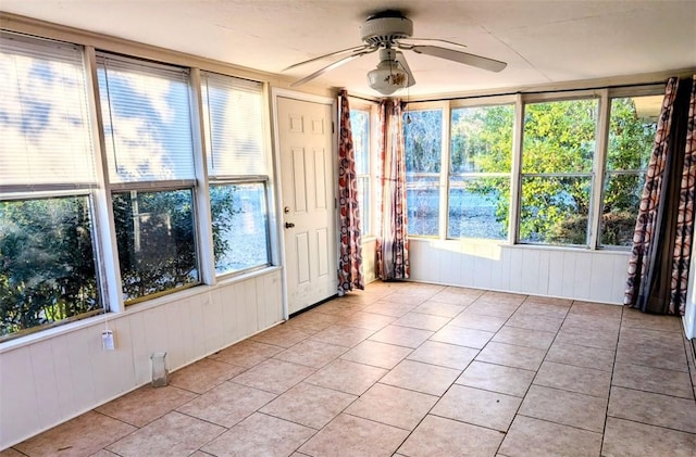 unfurnished sunroom featuring ceiling fan