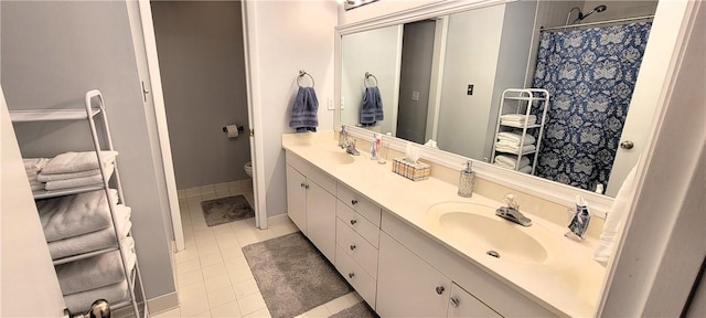 bathroom featuring tile patterned floors, a sink, toilet, and double vanity