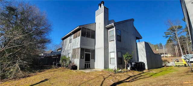 exterior space with a lawn, a chimney, and fence