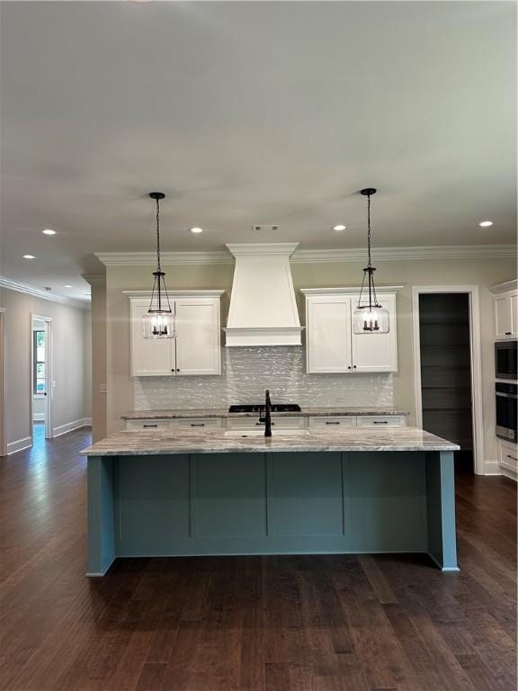 489 Windsor Dr, Opelika, AL 36801 - kitchen with premium range hood, light stone counters, white cabinets, backsplash, and a spacious island